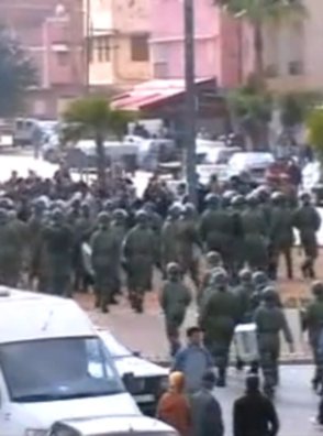Unidades antidisturbios de la policía en Kenitra, Marruecos, fluyendo hacia la pacífica multitud 