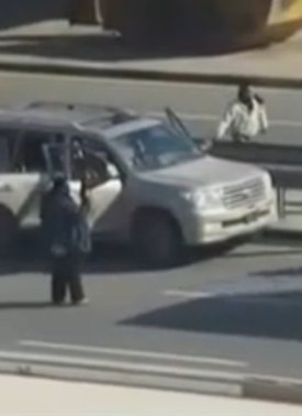 Dark-skinned persons loading arms into vehicle